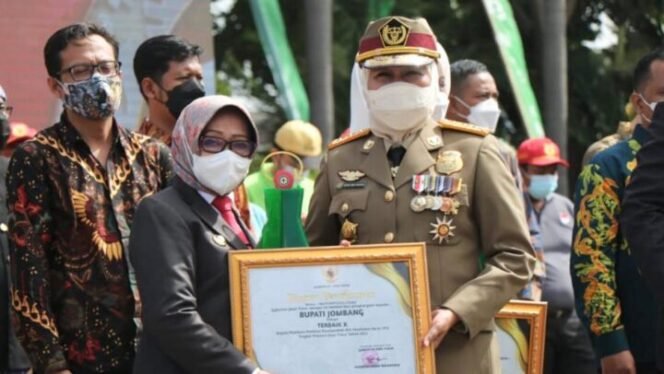 
					Bupati Jombang Hj. Mundjidah Wahab saat menerima penghargaan dari Gubernur Jatim Hj. Khofifah Indar Parawansa pada peringatan bulan keselamatan dan kesehatan kerja (K3) di halaman kantor Dinas Tenaga Kerja dan Transmigrasi Jawa Timur, Surabaya, Rabu (12/01/2022). (Foto: Kominfo Jombang)