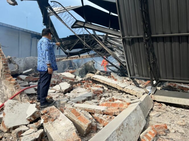 
					Kepala Dinas Pemadam Kebakaran Kabuoaten Gresik, AH Sinaga melihat puing-puing sisa kebakaran pabrik sound system di wringinanom, Gresik, Kamis (17/3/2022). (Foto: Istimewa)