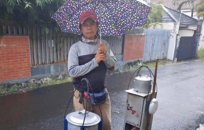 
					Pak Tija, lelaki 40-an tahun ini masih terus setia menjajakan kudapan kembang tahu jahe menyusuri jalanan kota Jakarta, meski harus berhujan-hujan. (Foto: SWARAJOMBANG.com/ Khristina Kencana)