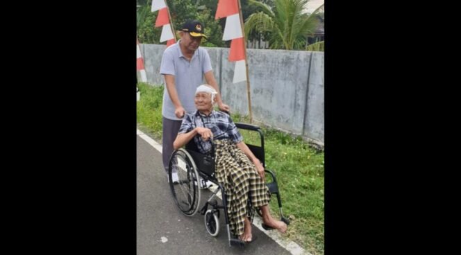
					Muhadjir sedang mendorong kakak nomor tiga, Ahmad Asfahani yang tengah sakit di atas kursi roda. (Foto: SWARAJOMBANG.com/ Anwar Hudijono)