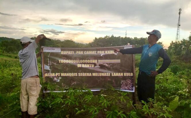 
					Dua orang warga Dusun Kwacang, Desa Sukodadi, Kecamatan Kabuh, Kabupaten Jombang, membentangkan spanduk yang bertuliskan: Bupati, Pak Camat, PakKades Tolooong Dibantu PT Manggis Segera Melunasi Lahan Kulo. (Foto: SWARAJOMBANG.com/ Wibisono).