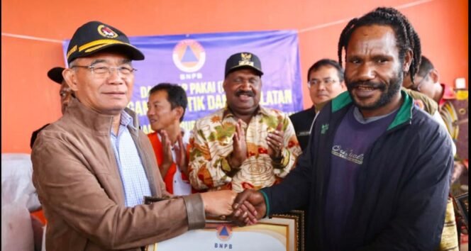 
					Menko PMK Muhadjir  Effendy bersama Kepala BNPB Suharyanto menyerahkan bantuan logistik kepada masyarakat korban bencana kekeringan dan kelaparan di Distrik Agangudume, Lambewi dan Oneri, Kabupaten Puncak, Provinsi Papua Tengah, di Bandara Mozes Kilangin Timika. Rabu (2/8/2023).  Penyerahan bantuan disaksikan Bupati Puncak Wilem Wandik. (Foto: SWARAJOMBANG.com/ Anwar Hudijono)