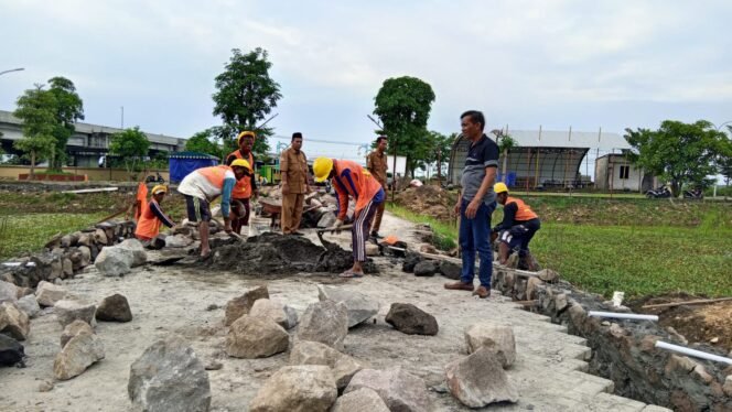 
					Foto:Istimewa
Pekerja tengah meneruskan pembangunan TPT di rest area Bumdes Pranti.