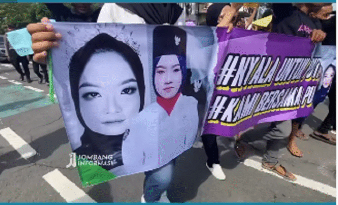 
					Keluarga korban PRA, 18, gadis Sebani yang menjadi korban kekerasan. Mereka 
membentangkan spanduk untuk meminta keadilan kepada pemerintah, khususnya kaum wanita anak yang menjadi korban kekerasan, dalam aksi unjuk rasa di depan gedung DPRD Jombang, Selasa 25 Februari 2025. Tangkap Layar Video Instagram@jombanginformasi_