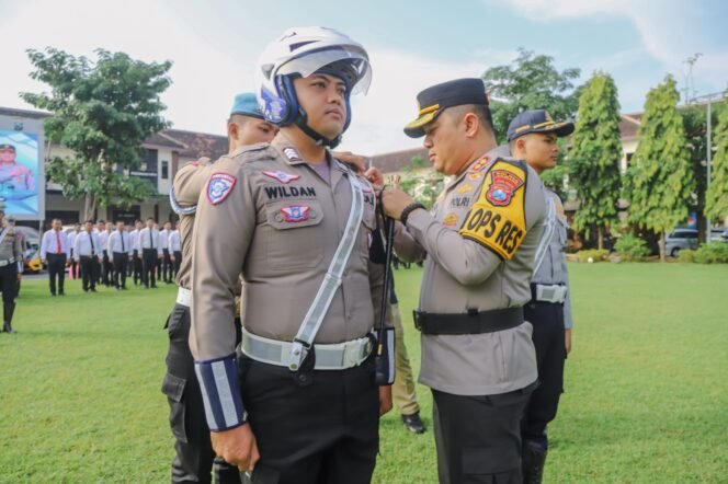 
					Kapolres saat sematkan pita kepada salah satu personel Operasi Patuh Semeru 2025
