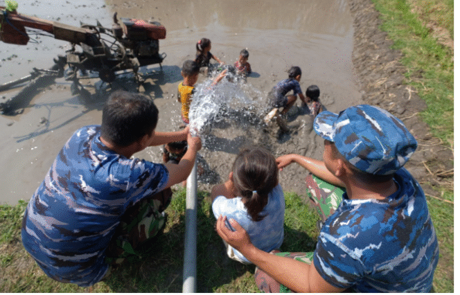 
					Prajurit TNI yang melaksanakan TMMD 125 di Ngusikan, Jombang,  sudah menghasilkan sumur bor untuk mengaliri sawa di desa Kromong. Tampak prajurit TNI bersama anak-anak desa bermain air di sekitar pematang sawah menggunakan air bersih dari sumur bor. Foto: Diskominfo Jombang