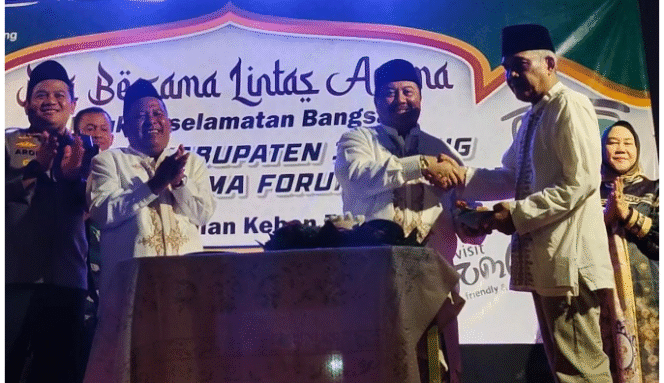 
					Buapti Warsubi memotong tumpeng dan menyerahkan kepada Koordinator Lapangan (Korlap) Forum Masyarakat Jombang (FRJ) Hartono, pada acara da bersama lintasa agama di Kebonrojo, Kamis malam 4 September 2024. Foto: jombangkanb.go.id