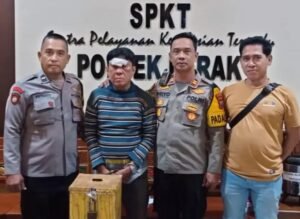pelaku diapit petugas dengan barang bukti