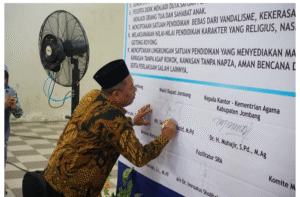 Wakil Bupati Jombang KH Salmanudin Yazid membubuhkan tanda tanga pada lembar Deklarasi Satuan Pendidikan Ramah Anak (SRA) sekaligus Pembukaan Program Fashlun Talenta (Fashta) di MTs Madrasatul Qur’an (MQ) Tebuireng, Selasa, 4 November 2025. Foto: Diskominfo Pemkab Jombang 