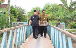 Wabup Jombang KH Salmanudin bersama beberapa staf meninjau lokasi jembatan rusak dan jembatan sementara di dusun banjarejo, desa Kunddubanjar, kecamatan Kudu, Jombang.  Pemkab sudah menganggarkan dan pembangunan jembatan ini, namun tiga kali gagal lelang sehingga akan dibangun tahun 2026. Foto: Jombangkab.go.id