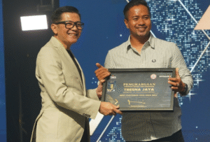 Direktur Sales dan Marketing SIG, Dicky Saelan (kiri) menyerahkan piagam penghargaan Best Customer kepada Kadek Agus Mudiana pada ajang Retailer Gathering SIG Area Bali tahun 2025,  di Nusa Dua Convention Center, Bali. Foto: Ist