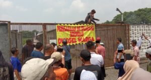 Pemasangan spanduk penolakan kandang ayam di dusun Bendo, Kumitir Jatirejo Mojokerto. (Foto.Gandung)