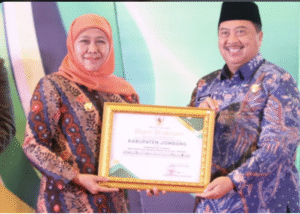Gubernur Jatim, Khofifah Indar Parawansa menyerahkan poiagam penghargaan kepada Bupati Jombang H Warsubi, sebagai Pemerintah Daerah Implementasi Prinsip Industri Hijau Terbaik se-Jawa Timur. dalam ajang Festival Industri Hijau Jawa Timur 2025, Selasa 2 Desemeber 2025, di Surabaya. Foto: jombangkap.go.id
