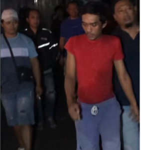 Polisi damn warga berhasil meringkus tersangka polisi yang sembunyi di lantai dua rumah warg di Desa Jotangan, Kecamatan Mojosari, Kabupaten Mojokerto, pada Minggu dini hari (28/12/2025). Ia berhasil diringkus berdasarakan laporan dua waria yan digoda oleh tersangka. Foto: tangkap layar video instagam@kabaraterdepanmojokerto