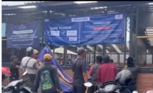 Aksi penolakan digitalisasi parkir di Mayjen Sungkono, Surabaya, disertai pencabutan dan perobekan spanduk di depan aparat keamanan, terjadi Jumat 26 Desember 2025. Foto: Tangkap layar video Instagram@surabayakabarmetro