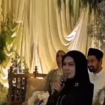 Kedua mempelai duduk bersanding di pelaminan, teralangi wajah MC, dalam video disebut sebagai acara pernikahan antara gubernur Aceh Muazkie Manaf alias Mualem dengans eorang wanita Malaysia yang tidak disebut namanya. Foto: Instagram@metronews.co