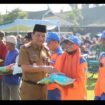 Sekda Jombang, Agus Purnomo menyerahkan bantuan berupa uang tunai Rp100.000 dan 5 kh beras, dibagikan kepada 2.495 warga di lapangan upcara pemkab, Senin 16 Maret 2026. Foto: diskominfo pemkab jombang