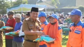Sekda Jombang, Agus Purnomo menyerahkan bantuan berupa uang tunai Rp100.000 dan 5 kh beras, dibagikan kepada 2.495 warga di lapangan upcara pemkab, Senin 16 Maret 2026. Foto: diskominfo pemkab jombang