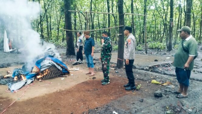 
					Petugas gabungan tengah memusnahkan arena dan peralatan judi sambung ayam