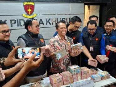 Wagiyo Santoso Aspidsus Kejati Jatim menunjukkan uang yang diamankan dari kantor dan rumah ketiga tersangka yang terlibat dalam kasus dugaan pungutan liar di lingkungan Dinas ESDM Jatim. Foto: Akira suarasurabaya.net 