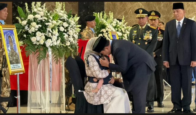
					Presiden Prabowo Subianto memeluk dan menciun kening bayi, yang digendong istri mendiang Serka Anumerta Muhammad Nur Ichwan, prajurit TNI yang gugur di medan pengabdian UNIFIL di Lebanon. Presiden melepas untuk terakhir kali kepada tiga prajurit TNI ke pemakaman. Foto: ist