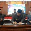 Bupati Warsubi membubuhkan tanda tangan pengesahan Perda Barang Milik Daerah, dalam sidang paripurna, di gedung DPRD, Senin, 4 Mei 2026. Foto: instagram@swarajombang.com
