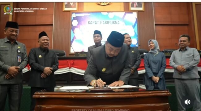 Bupati Warsubi membubuhkan tanda tangan pengesahan Perda Barang Milik Daerah, dalam sidang paripurna, di gedung DPRD, Senin, 4 Mei 2026. Foto: instagram@swarajombang.com
