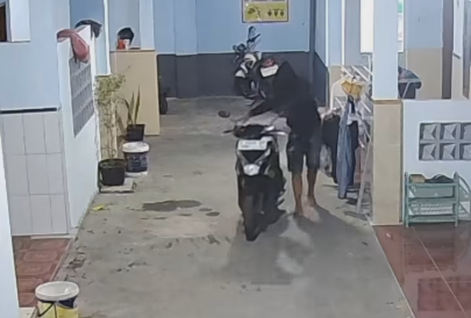 
					aksi pelaku terekam CCTV saat menuntun motor korban