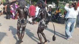 Kakan beradik Tarsipan dan Sinto mengecat tubuhnya dengan semir sepatu, turut serta memeriahkan pawai suguh dusun di desa Plumbon Gambang, kecamatan Gudo, Jombang, Sabtu 4 Juli 2026. Foto: swarajombang.com/ ipong dwicahyono