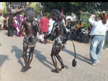 Kakan beradik Tarsipan dan Sinto mengecat tubuhnya dengan semir sepatu, turut serta memeriahkan  pawai suguh dusun di desa Plumbon Gambang, kecamatan Gudo, Jombang, Sabtu 4 Juli 2026. Foto: swarajombang.com/ ipong dwicahyono