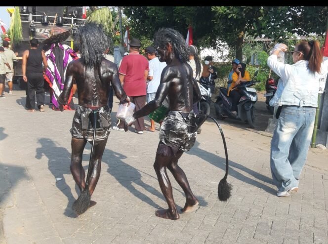 
					Kakan beradik Tarsipan dan Sinto mengecat tubuhnya dengan semir sepatu, turut serta memeriahkan  pawai suguh dusun di desa Plumbon Gambang, kecamatan Gudo, Jombang, Sabtu 4 Juli 2026. Foto: swarajombang.com/ ipong dwicahyono