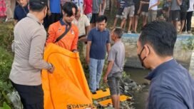 Petugas tengah mengevakuasi jasad bayi perempuan dari sungai setempat